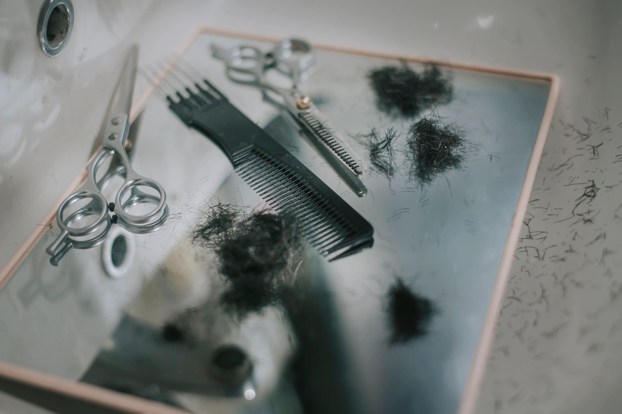 Barber scissors, comb, and mirror after a haircut
