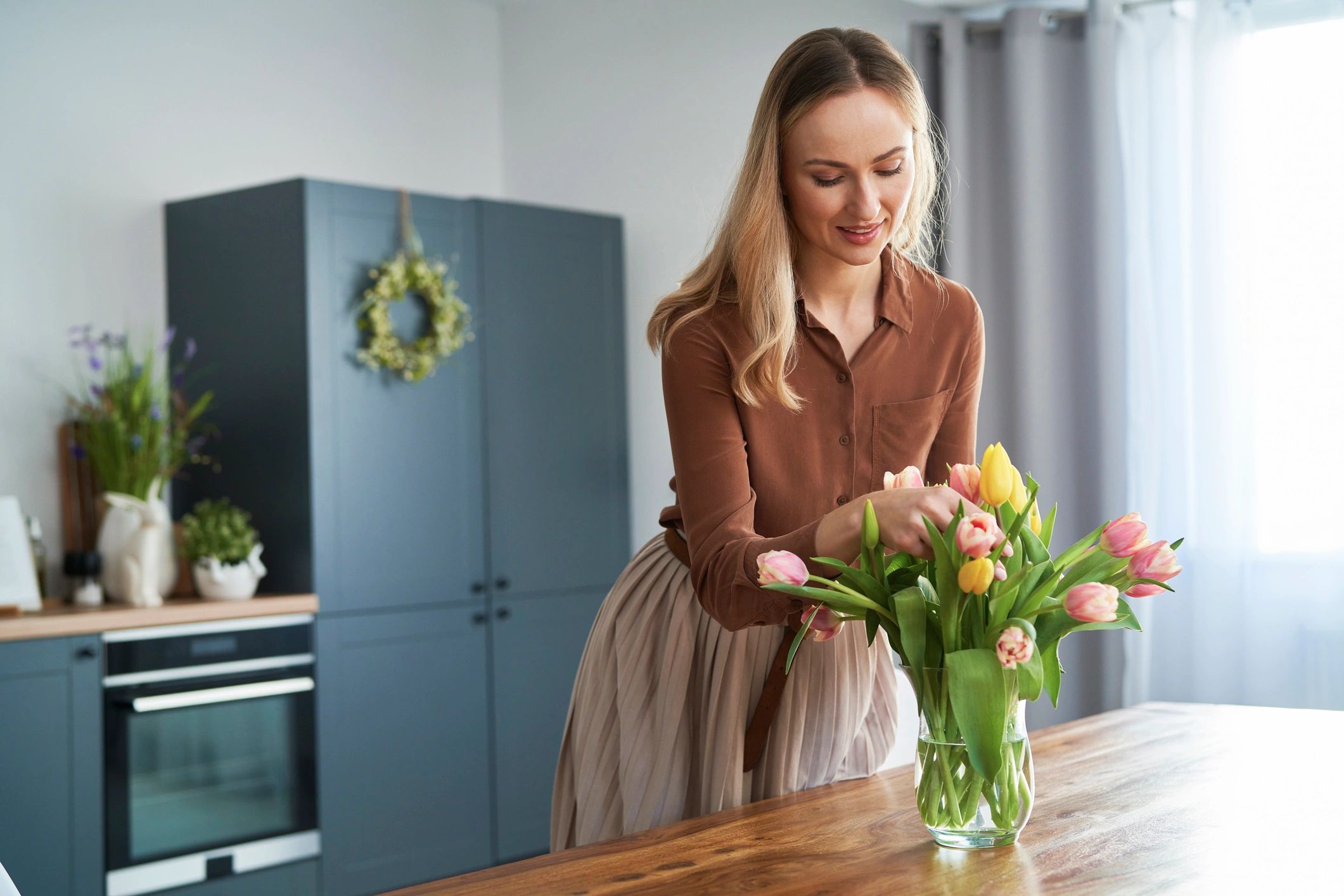 Florist arranging fresh tulips in a vase