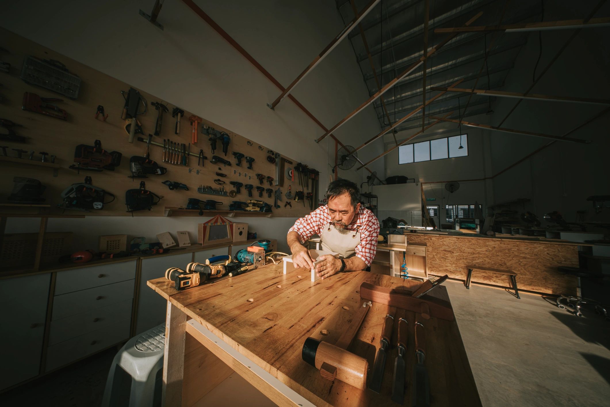 Carpenter measuring wood in a workshop